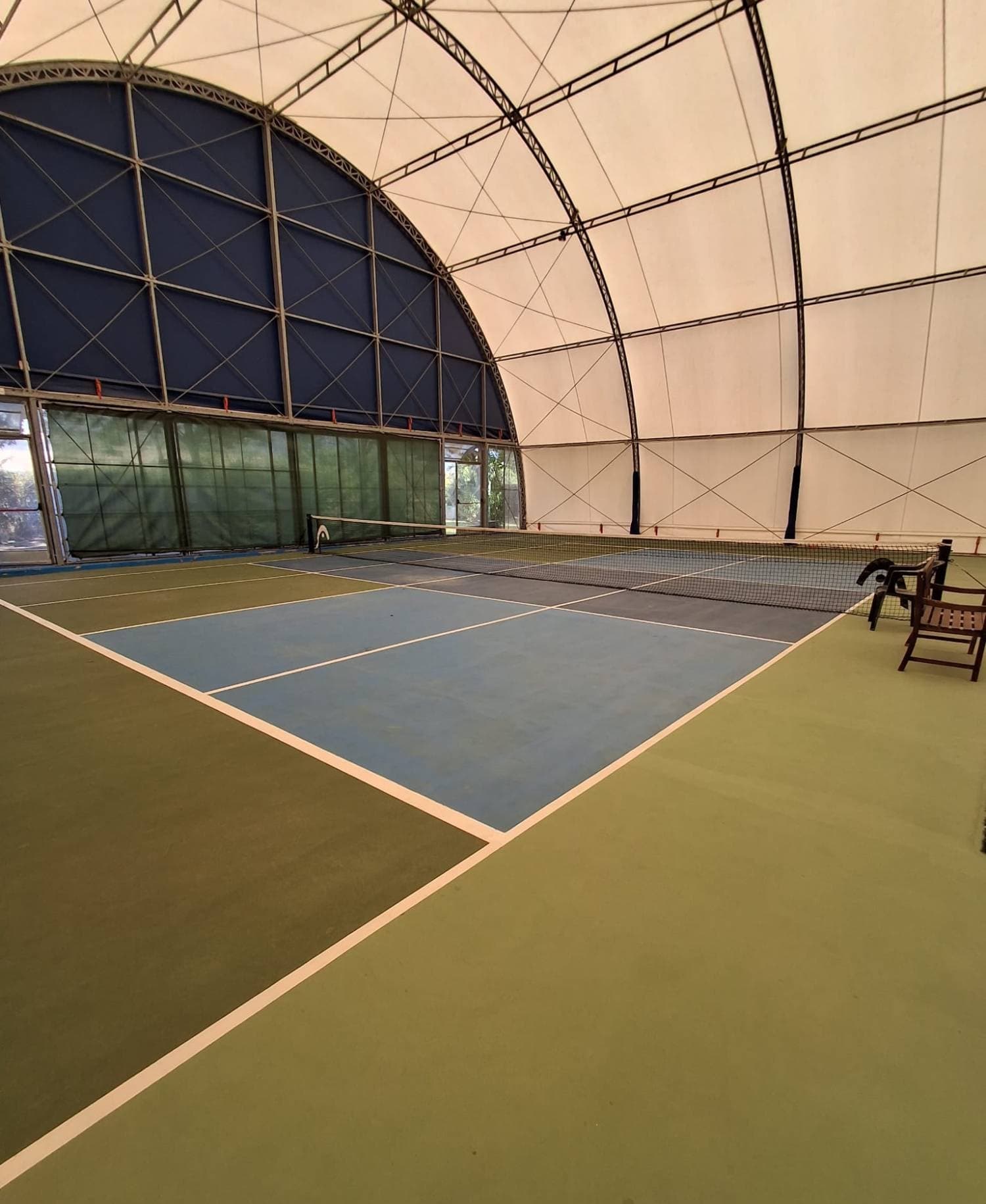 Campo da pickleball coperto, superficie blu e grigia con contorno verde